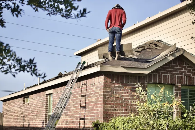 Professional roofer working on a residential roof in Freedom